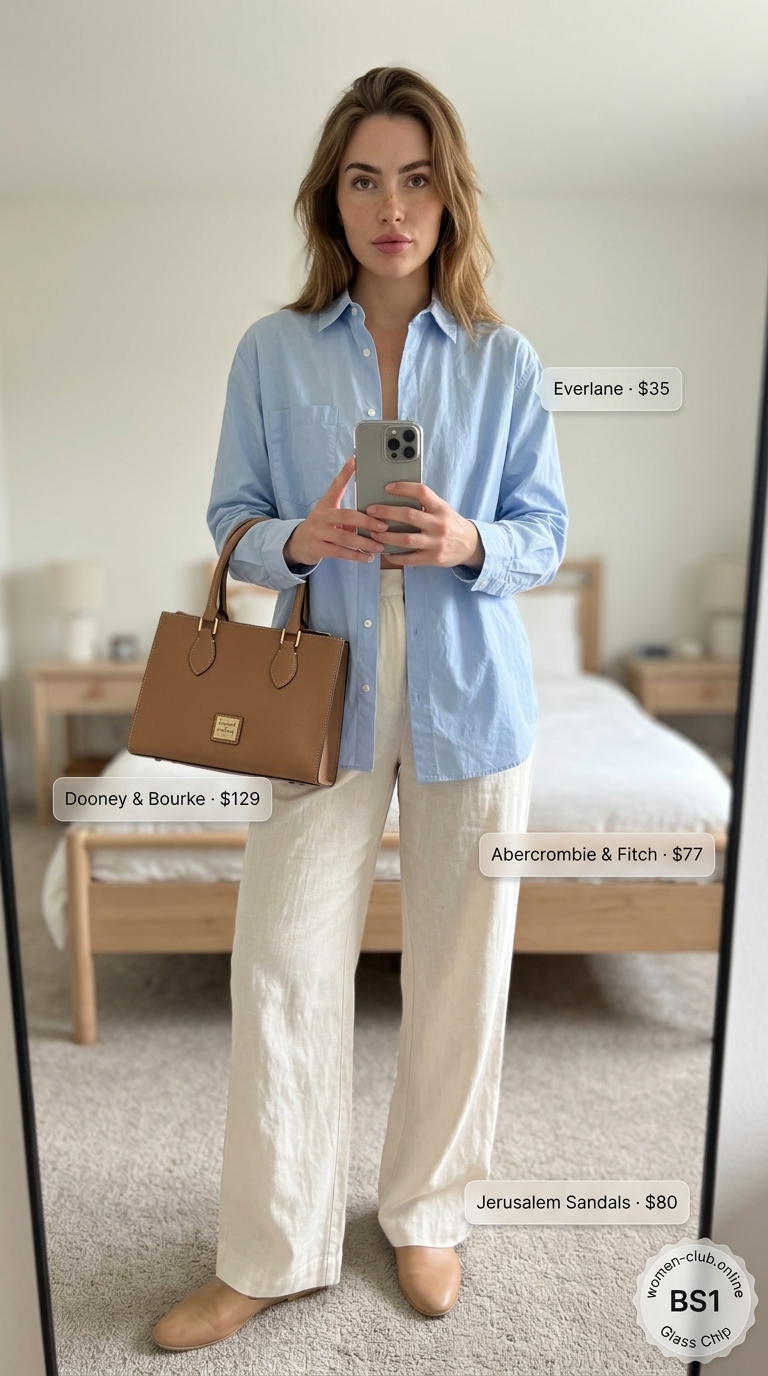 Polished minimal hot weather summer outfits for women 2026. White linen wide-leg trousers, a light blue relaxed button-down shirt, tan flat mules, and a structured tote bag for office casual.